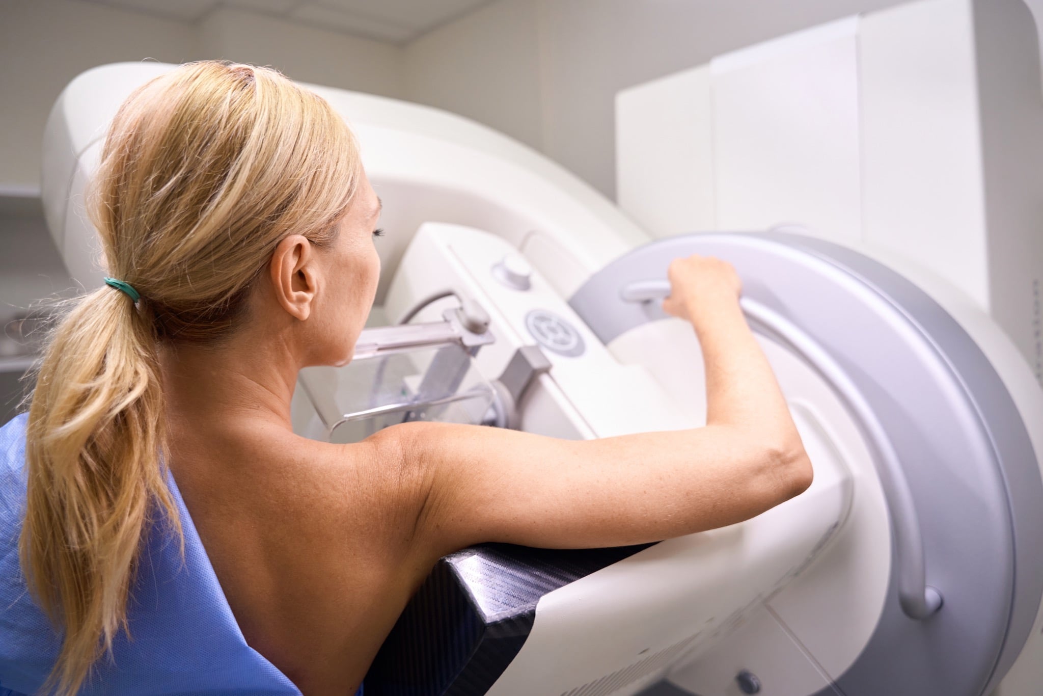Patient positioned at a mammography unit during a contrast enhanced mammography exam